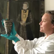 Foto på kvinna som håller arkeologisk bägare.