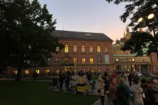 Historiska museet i skymning. Framför huset står en stor folkmassa.
